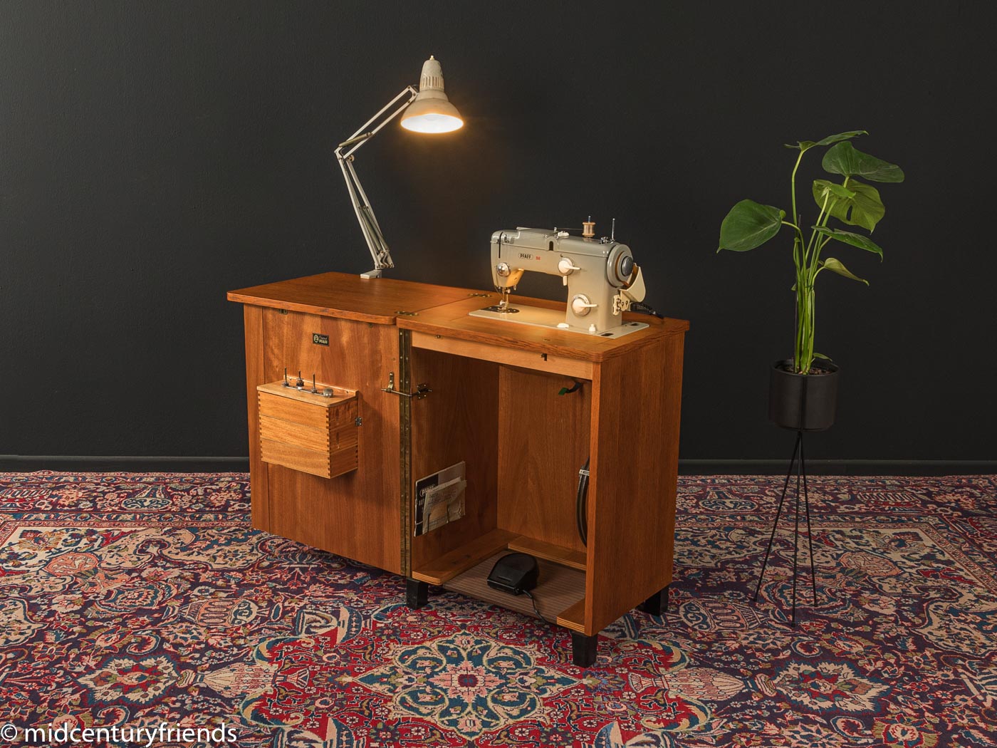 Vintage Pfaff Automatic 260 sewing machine in wooden oak cabinet on patterned rug with lamp and plant