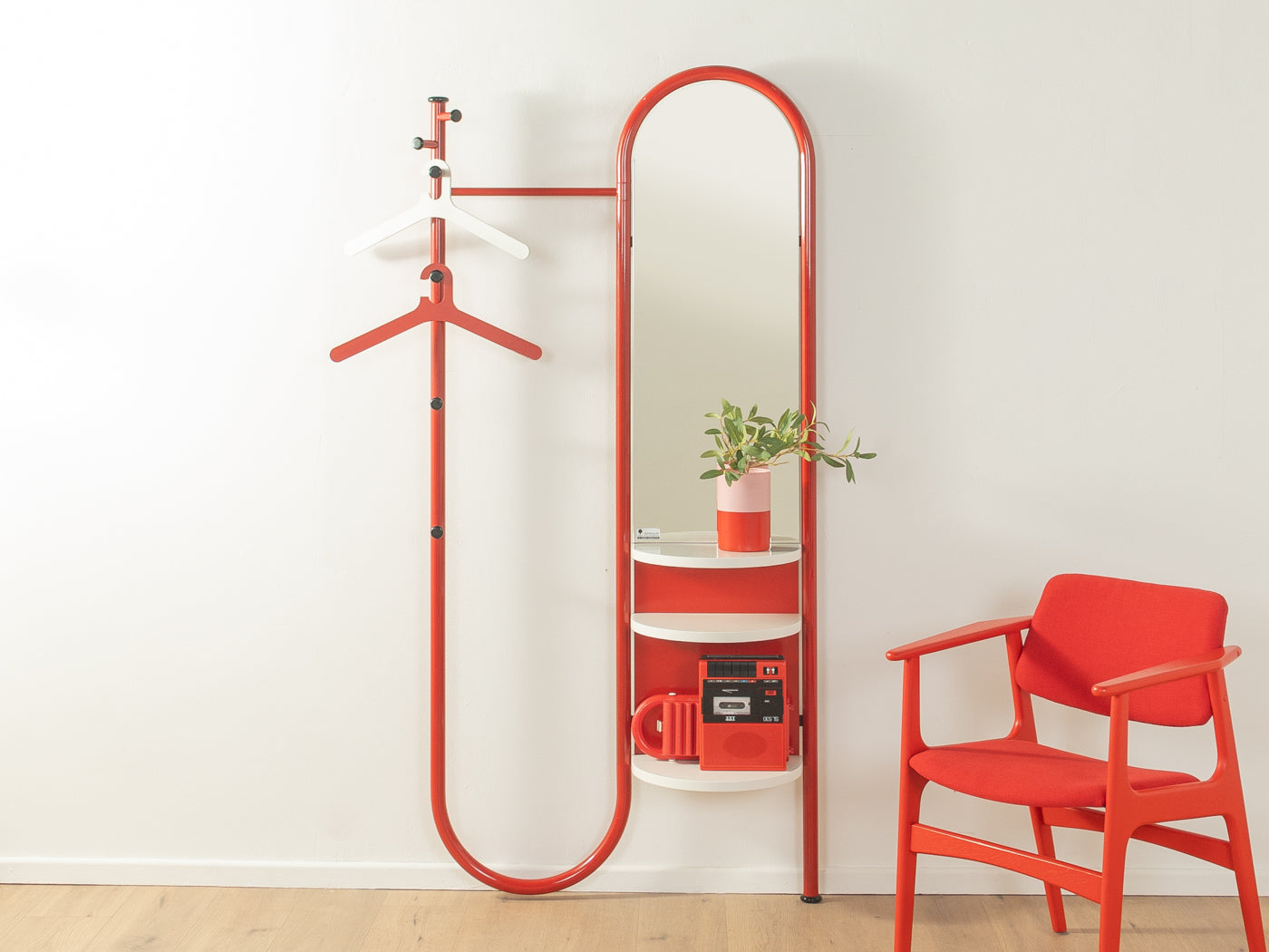 Schönbuch Garderobe aus den 1970er Jahren mit rotem Metallgestell, sechs Kleiderhaken, Spiegel und weißen Ablagen.